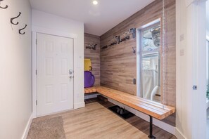 A hallway with a bench, a door, and a window with a view. - Gorgeous townhouse | Private hot tub | BBQ (Whistler)