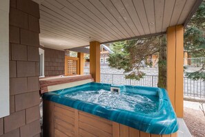 A hot tub under a wooden pergola with a view of a residential street. - AC in bedrooms | Private hot tub | Pets | Location (Whistler)