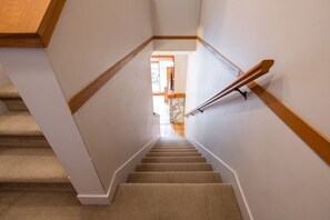 A staircase with carpeted steps, wooden handrails, and white walls. - Private Hot Tub | BBQ | Free parking | Ski-in/out (Whistler)