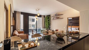 A modern hotel room with a kitchen area, dining space, and a balcony with a view. - San Luis by Kukun Apartments (Ciudad de México)