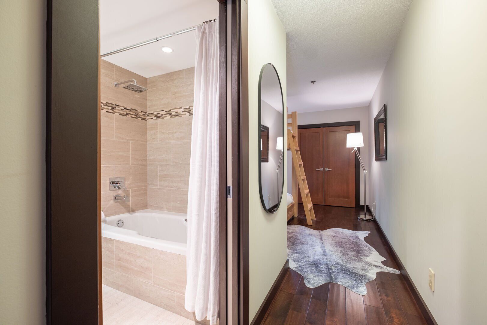 A bathroom with a bathtub, shower, and a white curtain.