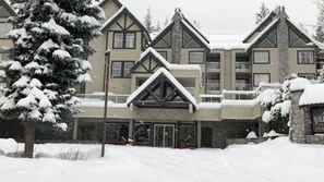 A multi-story building with a symmetrical facade, large windows, and a stone entrance. - Stunning 2 BDR | Steps to Blackcomb | Free Parking | Shared hot tub (Whistler)