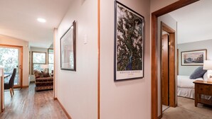 Un couloir avec un lit, une chaise et une œuvre d’art encadrée accrochée au mur.