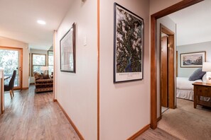 A hallway with a bed, a chair, and a framed artwork on the wall. - Close to Blackcomb skiing | Private hot tub | BBQ (Whistler)