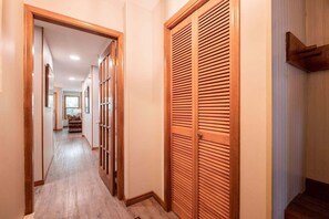 A hallway with wooden doors, a carpeted floor, and a staircase leading to another level. - Close to Blackcomb skiing | Private hot tub | BBQ (Whistler)