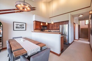 Eine moderne Küche mit Holzschränken, Edelstahlgeräten und Pendelleuchten.