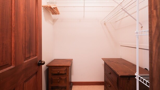Ein Schrank mit Holztüren, einem Drahtgitterregal und einem kleinen Holzschrank.