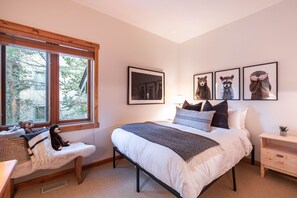 A bedroom with a bed, bedside tables, a window, and wall art. - Pets | BBQ | Sundeck | Private garage | Ski-in/out (Whistler)