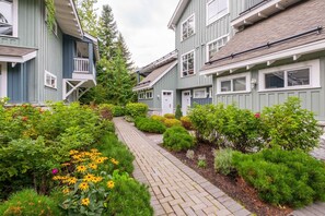 A row of two-story houses with a brick pathway and well-maintained gardens. - Pets | BBQ | AC in bedrooms | Superb location (Whistler)