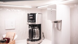 Une cuisine moderne équipée d’une machine à café et d’un distributeur d’eau.