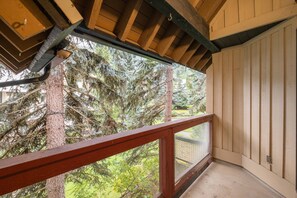 A wooden balcony with a view of snow-covered trees and a house in the background. - Pet friendly | Renovated | Free parking | Spacious (Whistler)