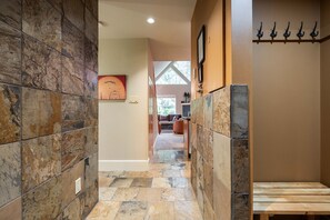 A hallway with stone walls and a wooden bench. - Free Parking | Steps to Blackcomb | Shared Hot Tub (Whistler)