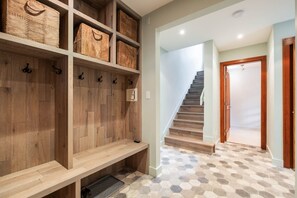 Un pasillo con un banco de madera, una escalera y una puerta.