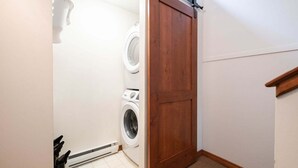 Ein Waschraum mit Holztür, Waschmaschine und Trockner.
