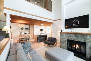 A modern interior with a living room, kitchen, and dining area. - BBQ | Free Parking | Spacious | Forest views (Whistler)