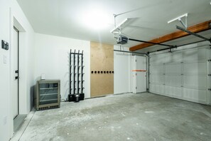 Eine Garage mit Betonboden, einer Holztür und einer weißen Garagentür.