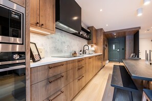 Una cocina moderna con armarios de madera, electrodomésticos de acero inoxidable y encimera de mármol.