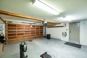 Eine Garage mit Holztür, Deckenventilator, Steckdose und Klingel.