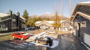 A residential area with houses, parked cars, and a mountain in the background. - Private Bike Storage | Free parking | Mountain Views | Window AC (Whistler)