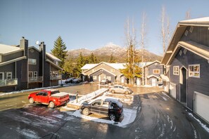 A residential area with houses, parked cars, and a mountain in the background. - Private Bike Storage | Free parking | Mountain Views | Window AC (Whistler)