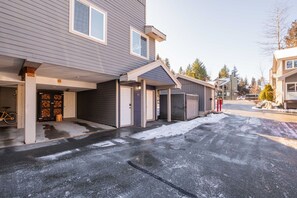 A residential building with a garage, a covered entryway, and a bicycle parked inside. - Private Bike Storage | Free parking | Mountain Views | Window AC (Whistler)