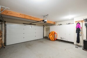 Eine Garage mit weißer Garagentür, Deckenventilator und einem farbenfrohen Heißluftfritteuse auf dem Boden.