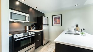 Una cocina moderna con microondas, estufa, horno y refrigerador incorporados.