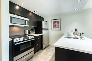 Eine moderne Küche mit integriertem Mikrowellenherd, Herd, Backofen und Kühlschrank.