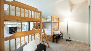 A bunk bed room with a ladder, a desk, and a floor lamp. - Beautiful Condo | Shared hot tub | BBQ | Wifi (Whistler)
