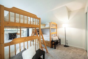 A bunk bed room with a ladder, a desk, and a floor lamp. - Beautiful Condo | Shared hot tub | BBQ | Wifi (Whistler)