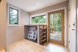 A room with a built-in shelf, a window, and a door leading to an outdoor area. - Luxury Home | Private hot tub | Pets | BBQ | AC (Whistler)