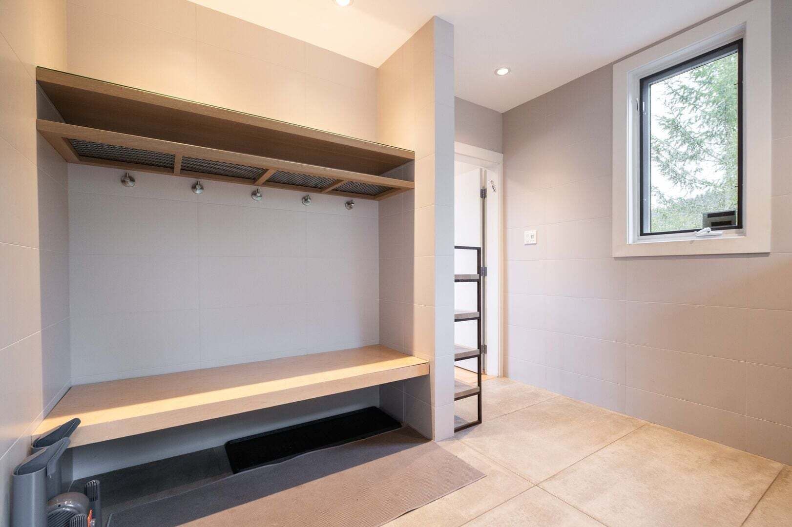 A modern bathroom with a built-in shower, a window, and a towel rack.