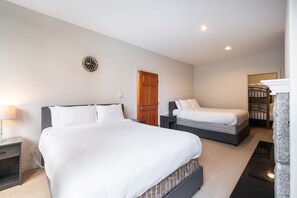 Ein Hotelzimmer mit zwei Betten, einer Holztür, einer Wanduhr und einem Schlafkoje im Eck.