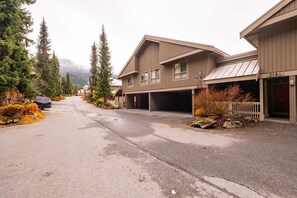 A two-story building with a garage and a covered entrance. - Townhome | Smart TVs | Pets | BBQ | Blueberry Hill (Whistler)