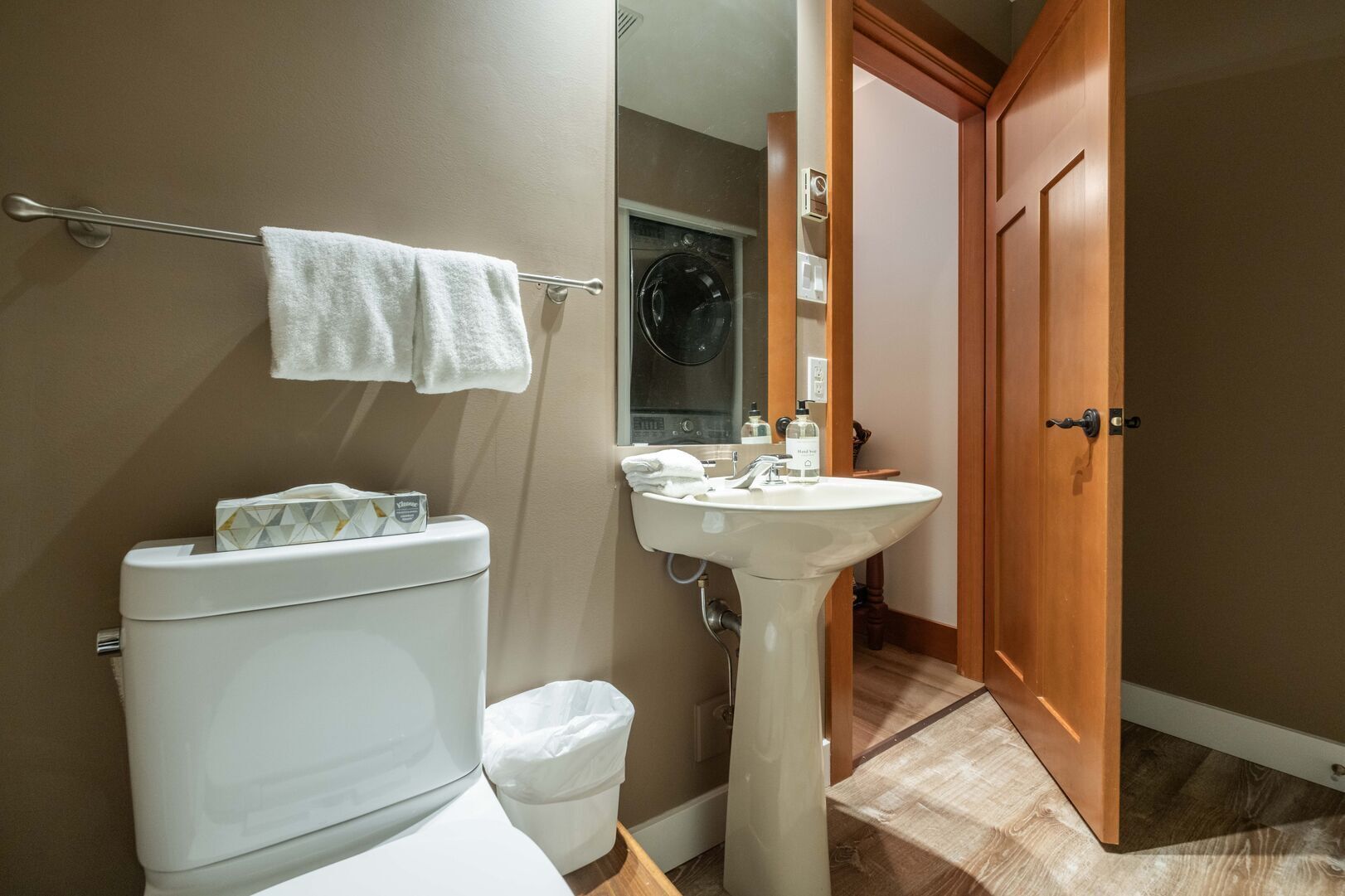 A bathroom with a toilet, a sink, and a mirror.