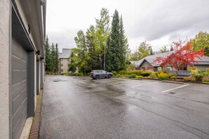 A residential street with a parked SUV, houses, and trees. - Townhome BBQ | Smart TV | Private Garage | Wifi (Whistler)
