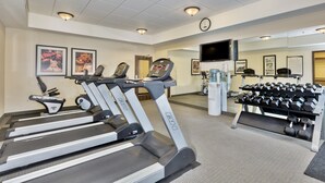 Ein Fitnessstudio mit Laufbändern, Kurzhanteln und Trainingsgeräten.