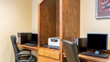 A workspace with two computer desks, one with a printer, and two office chairs.