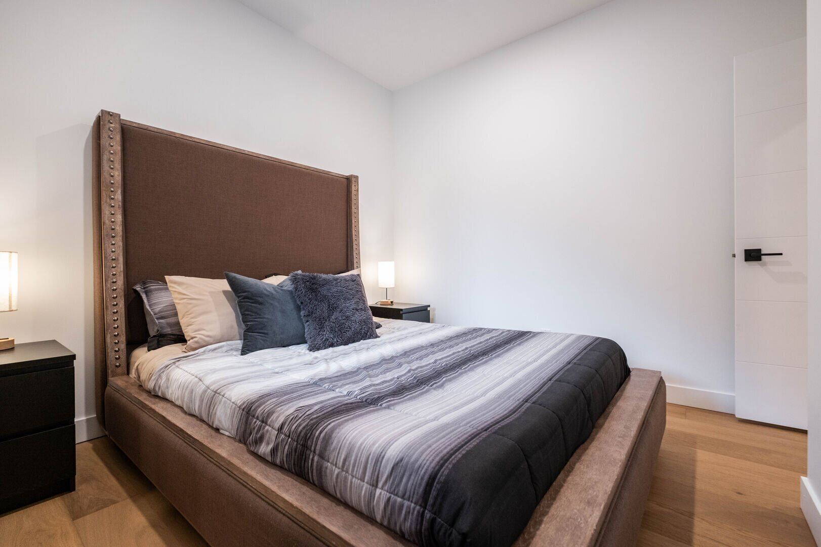 Ein modernes Schlafzimmer mit einem großen Bett, zwei Nachttischen und einem Beistelltisch.