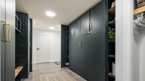 A hallway with dark cabinets, a white door, and a patterned rug. - Free Parking | Private hot tub | Blueberry Hill (Whistler)