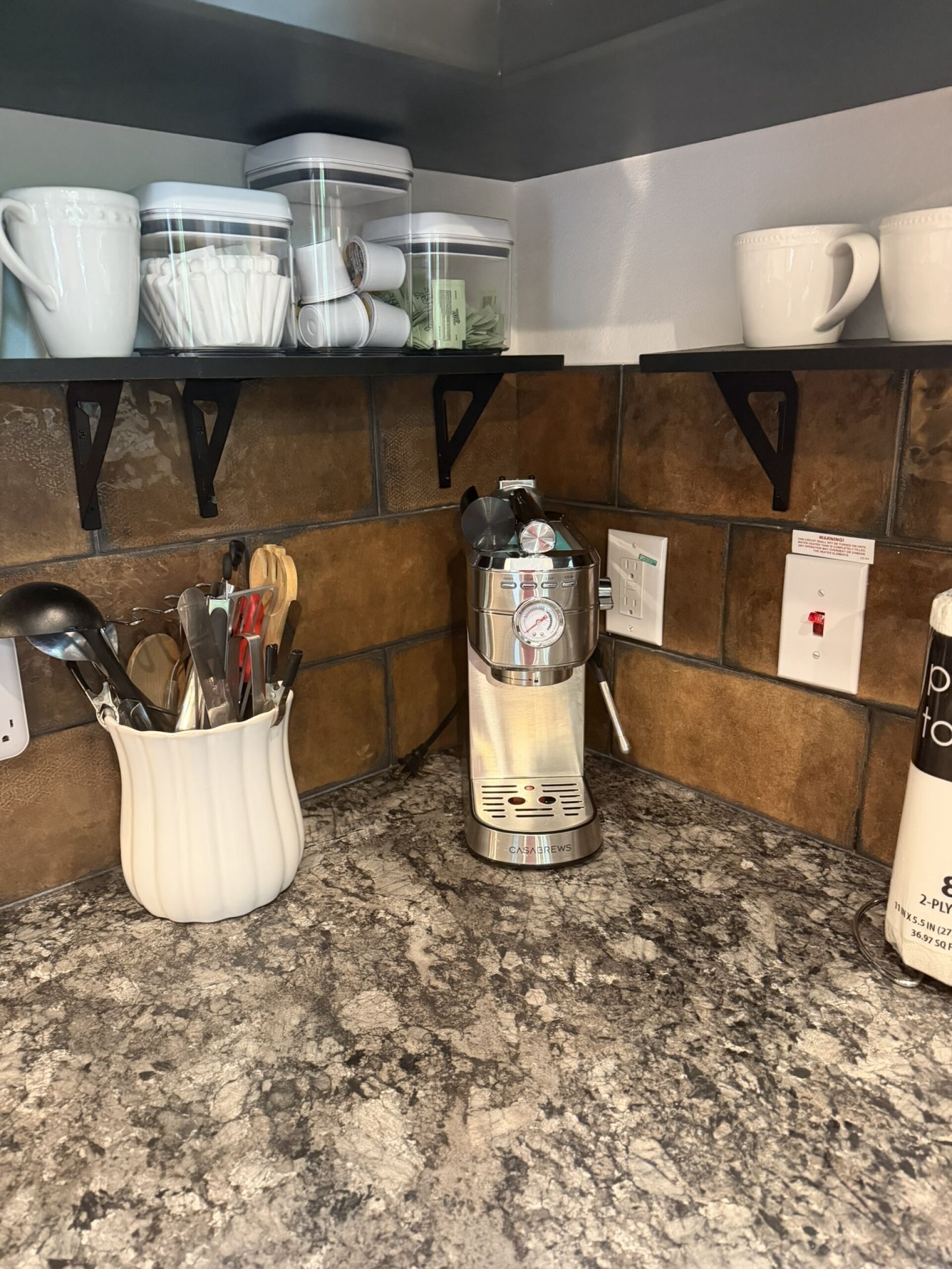 A kitchen with a coffee maker, utensils, and storage containers.
