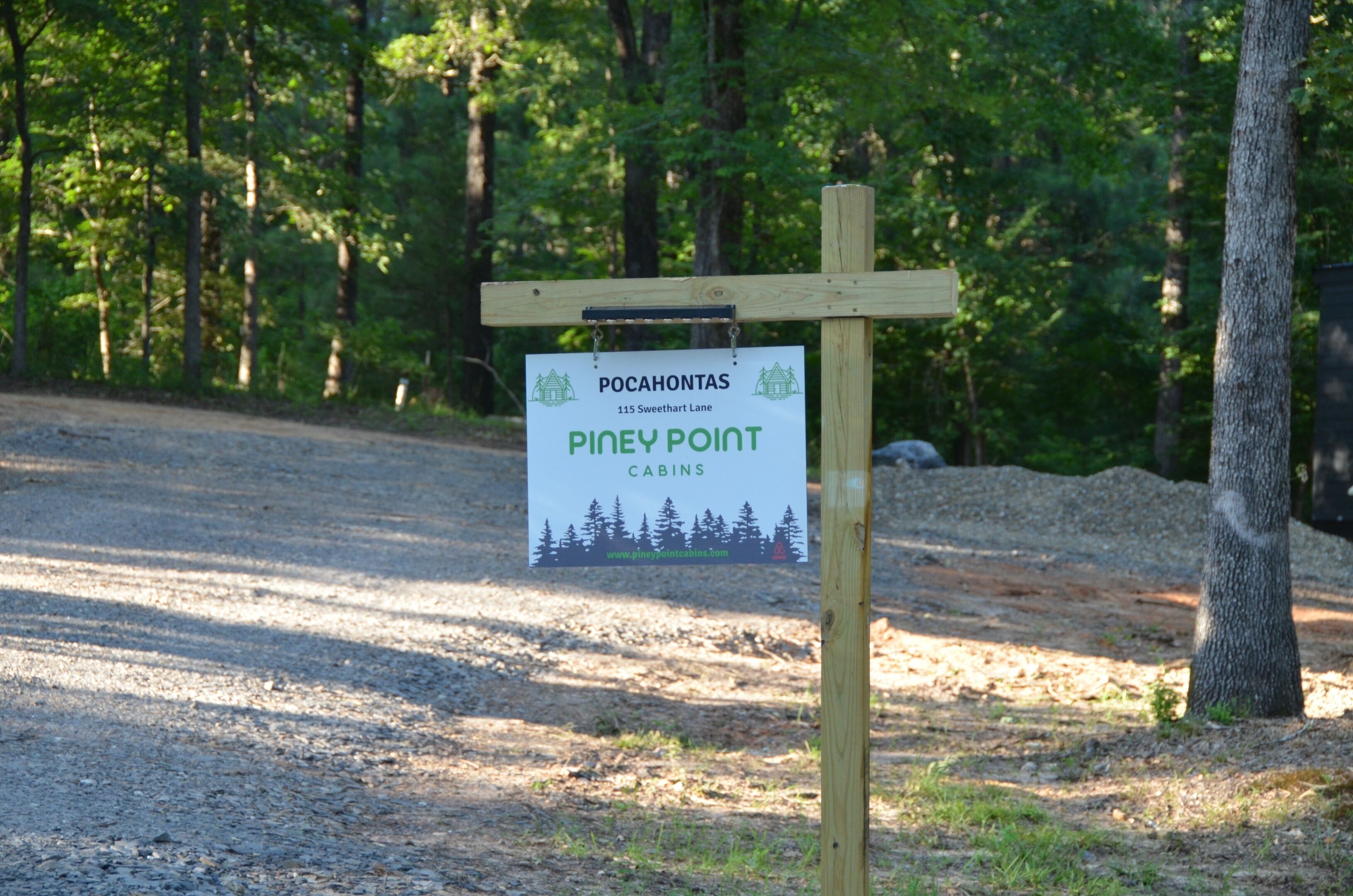 Cartel para Pocahontas Pines Point Cabins, con un bosque de fondo.