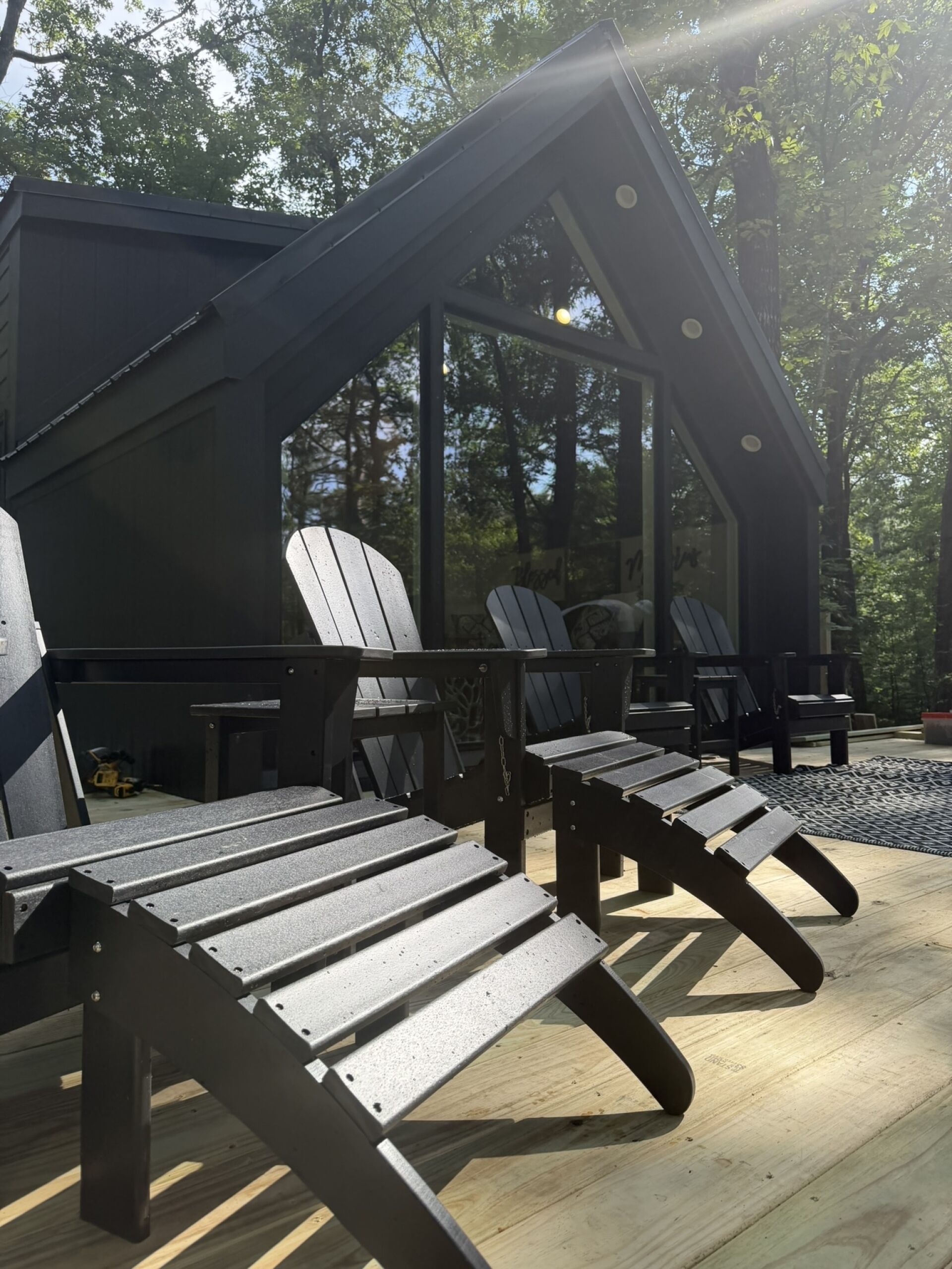 Un espacio de estar techado al aire libre con sillas Adirondack y una terraza de madera.