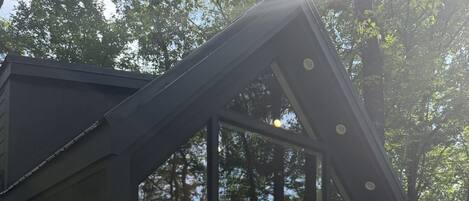 Un espacio de estar techado al aire libre con sillas Adirondack y una terraza de madera.