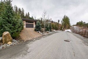 Ein Auffahrtsweg zu einer Garage mit einem Ziegelweg und verschneiter Landschaft.