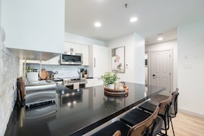 Uma cozinha moderna com uma ilha grande, eletrodomésticos de aço inoxidável e um design minimalista.