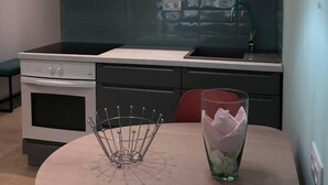 Een moderne keuken met een eettafel, een hanglamp en een glas water.