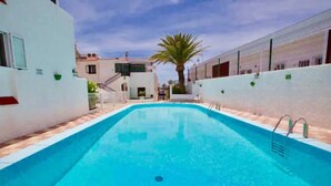 A rectangular swimming pool with a clear blue water surface, surrounded by white walls and a tiled floor. - Playa Troya Apartment at the beach (Costa Adeje)