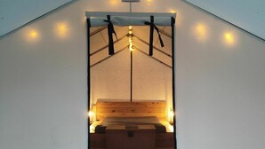 A tent-like structure with a bed, a sign, and a phone number. - Sorrel Tent | Canvas Tent with Lake Access (Kirkfield)
