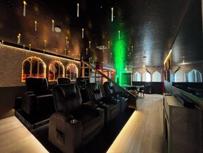A room with a dark ceiling, a green light, and a seating area with leather chairs. - 8 BD/ 6 BA/ Windsor Cay (16079 CC) (Clermont)
